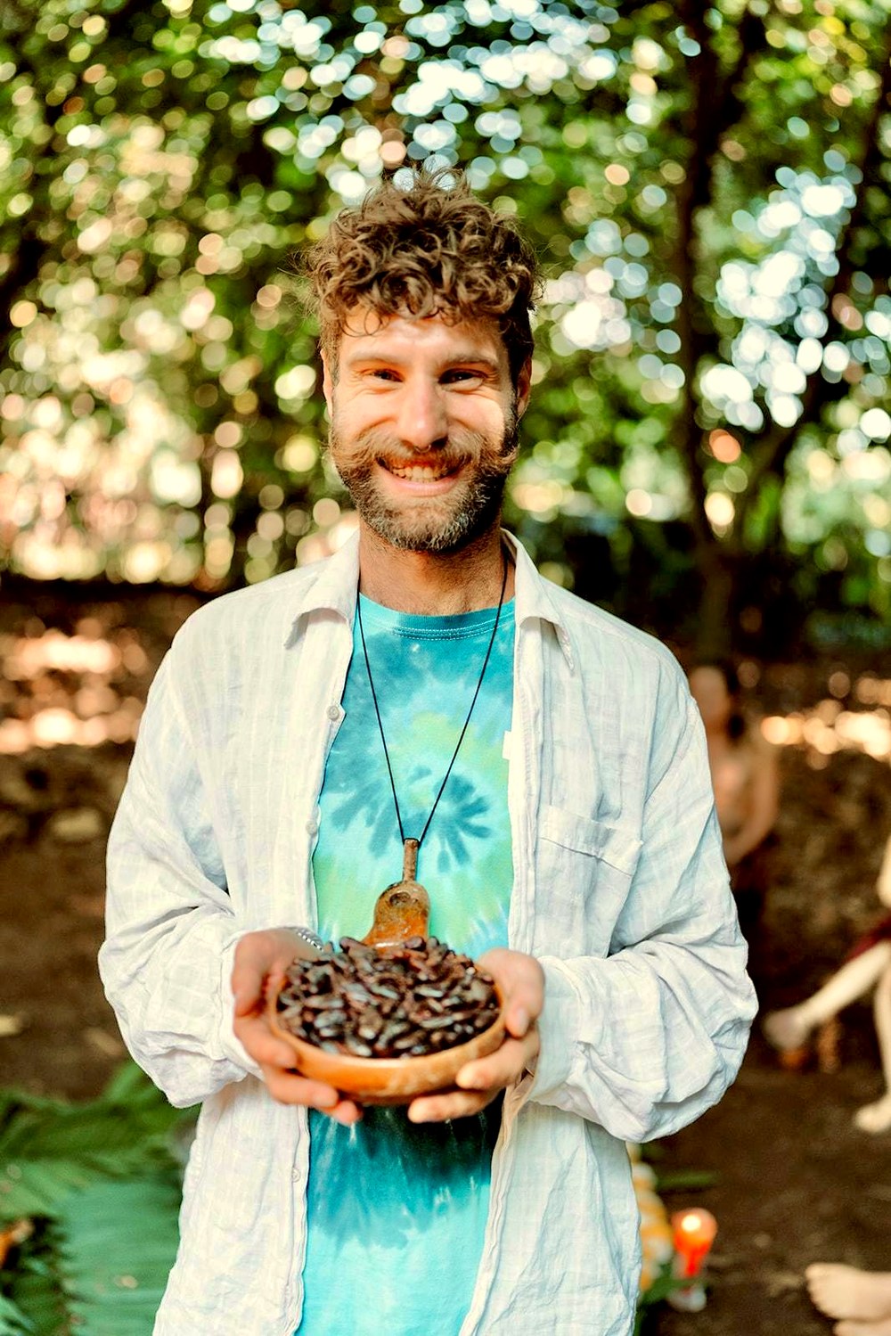 Will Finnie holding a bowl of cacao in the forest at the Mystical Yoga Farm